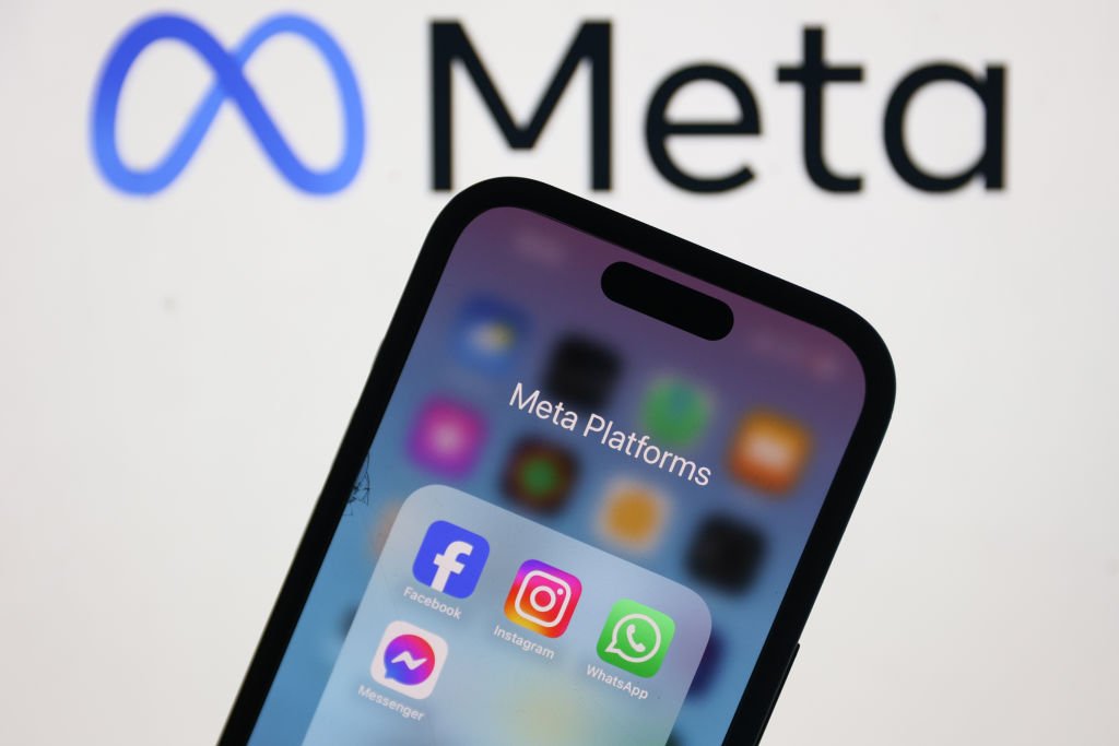 Meta logo displayed on a laptop screen and Facebook, Instagram, WhatsApp and Messenger icons displayed on a phone screen are seen in this illustration photo.