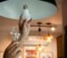 Hands switch an old light bulb out in a home pendant light.