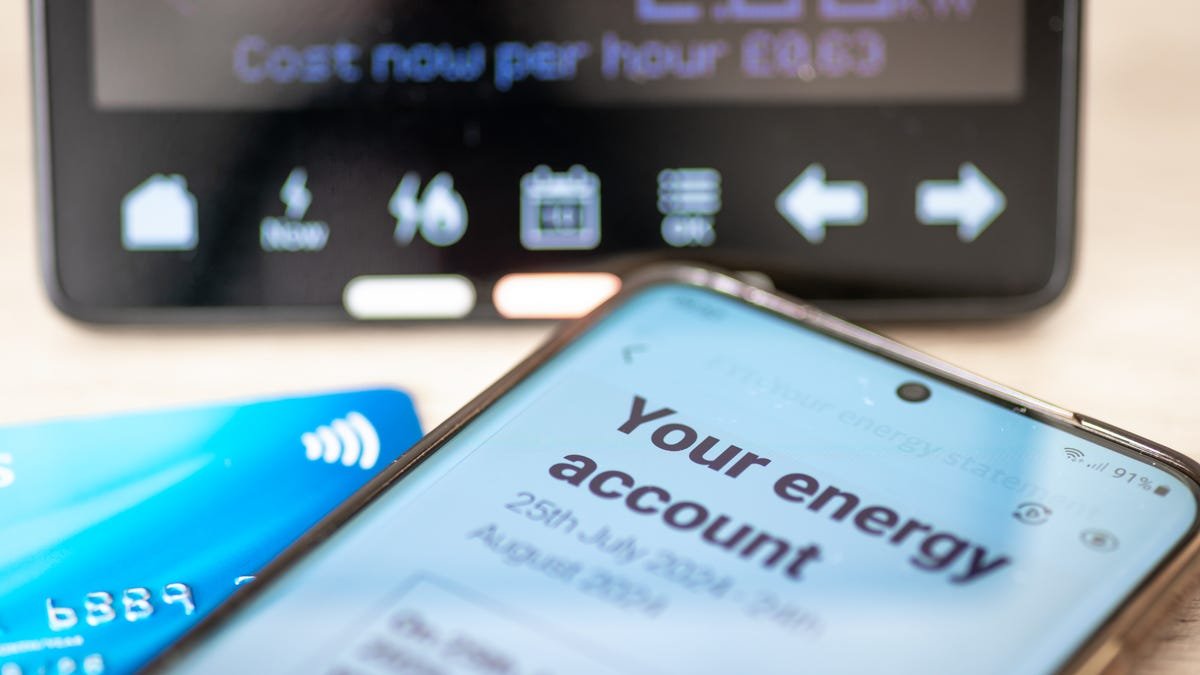 A cell phone displaying a digital energy bill, a bank card, and a smart energy meter.