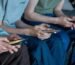 Three teenage boys look at their smartphone screens.